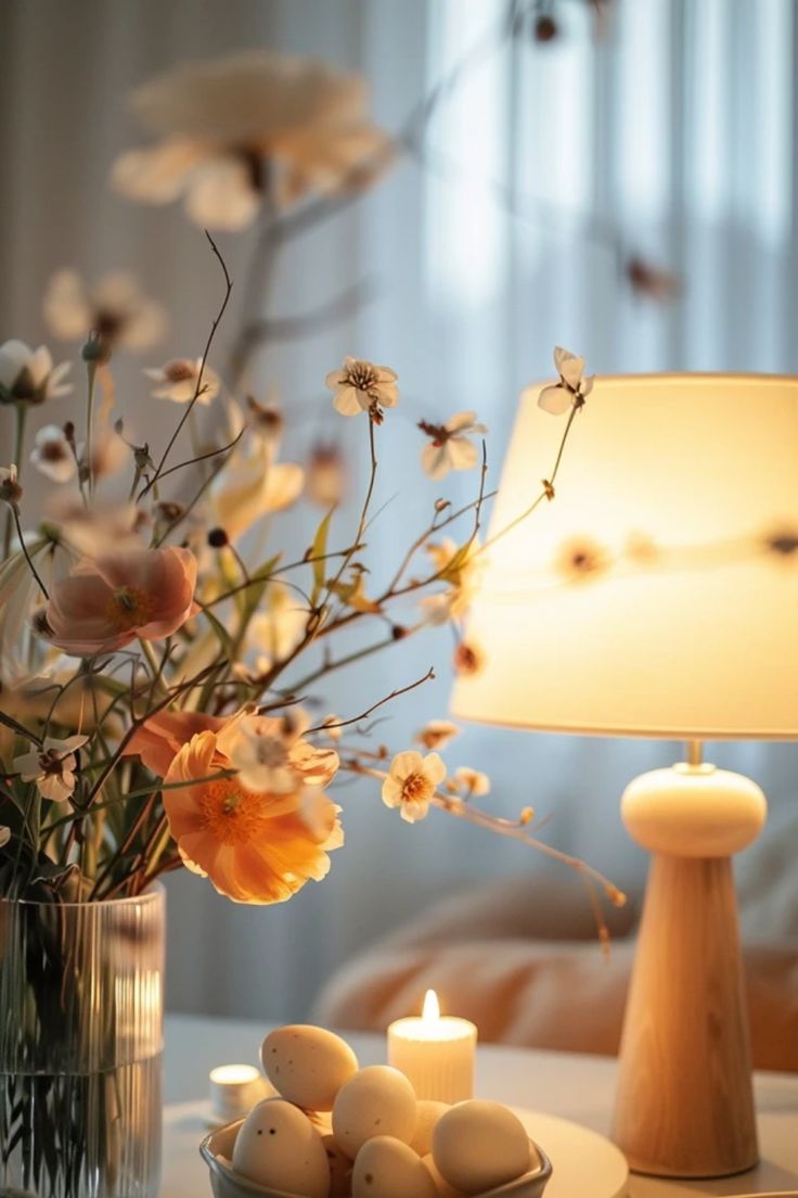 this picture contains a table lamp beside a flower vas